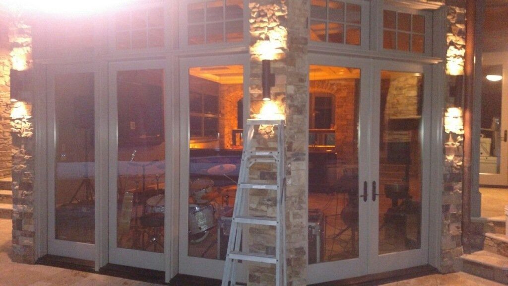 Ladder leaning against a glass storefront under warm lights at dusk