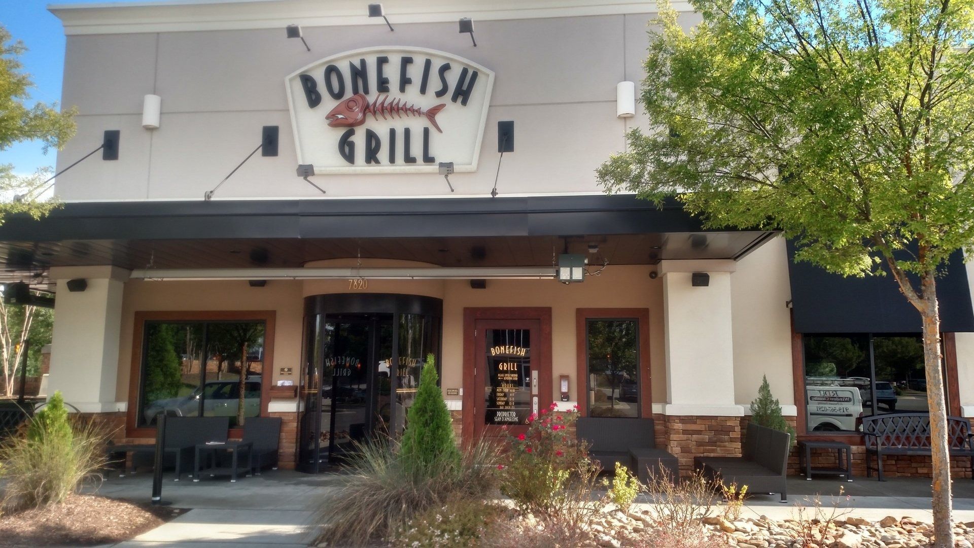 Bonefish Grill restaurant storefront with covered patio and outdoor seating under a sunny sky