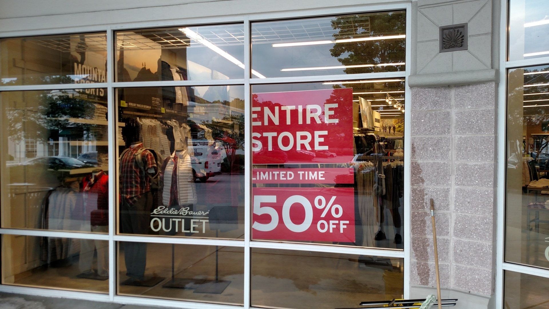 Storefront with large red sale signs advertising 50% off in the window