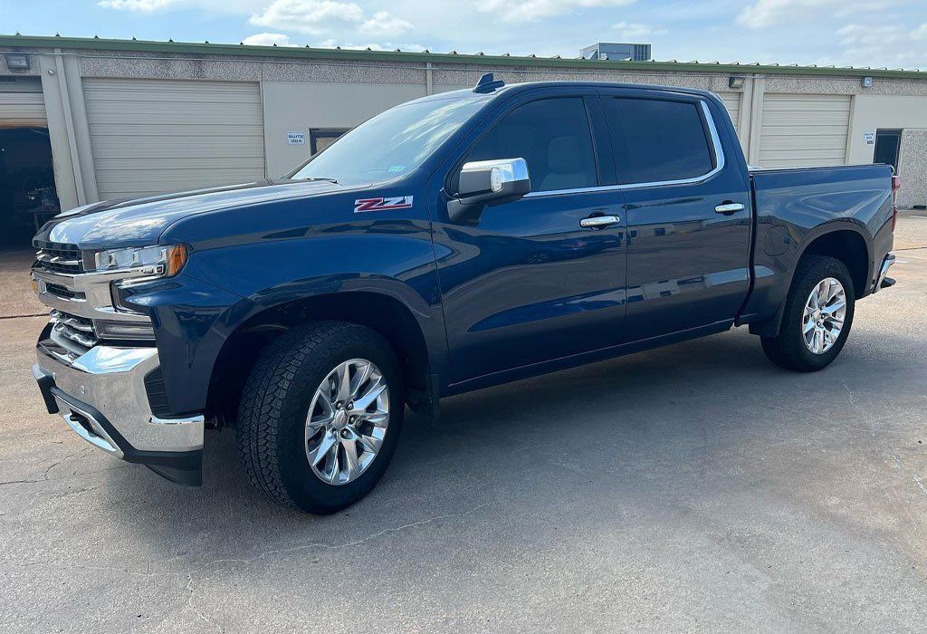 Blue Chevrolet Silverado pickup truck parked outside a building.