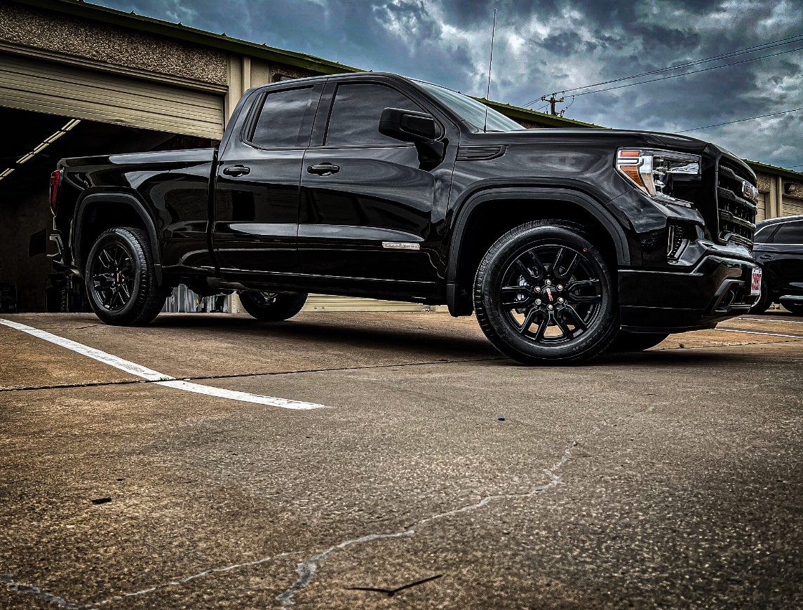 Black GMC pickup truck parked on asphalt.