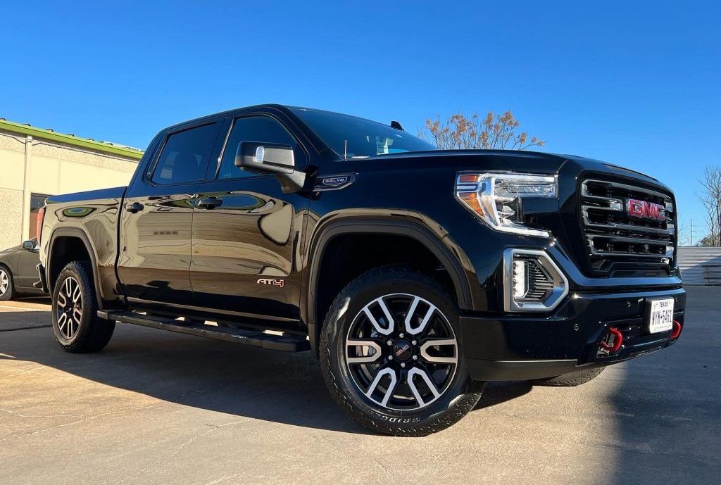 Black GMC Sierra truck parked outdoors on a sunny day.