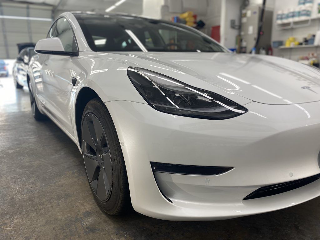 White Tesla electric car parked inside a garage.