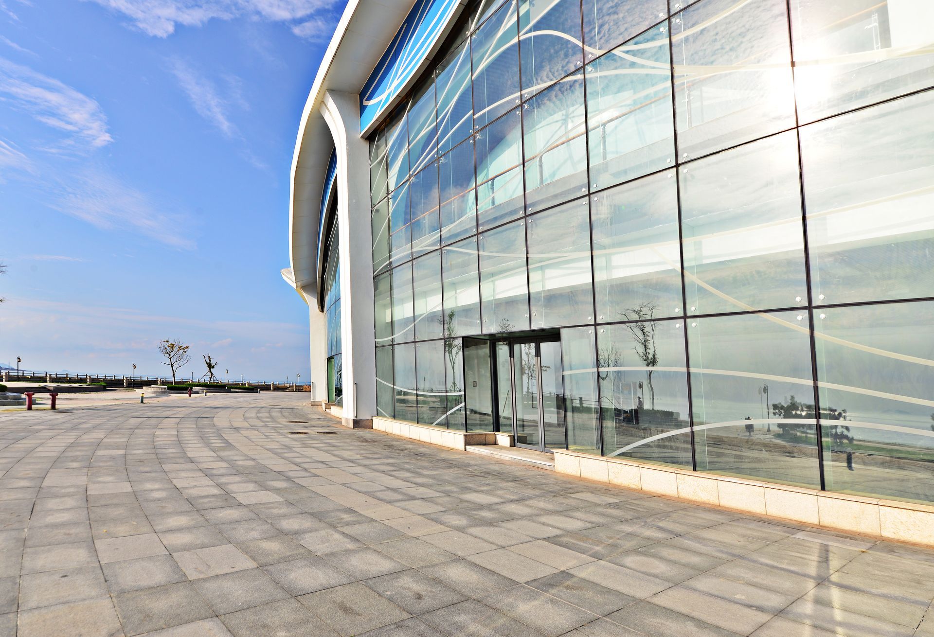 Exterior building facade with a window reflecting sunlight and a small balcony.