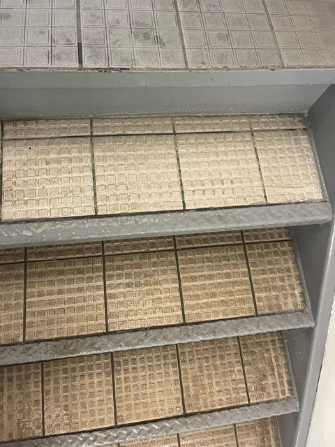 Étagères métalliques à plusieurs niveaux composées de carreaux carrés, clairs et texturés.