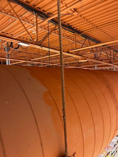Plafond et structure porteuse orange avec une structure cylindrique orange en dessous.