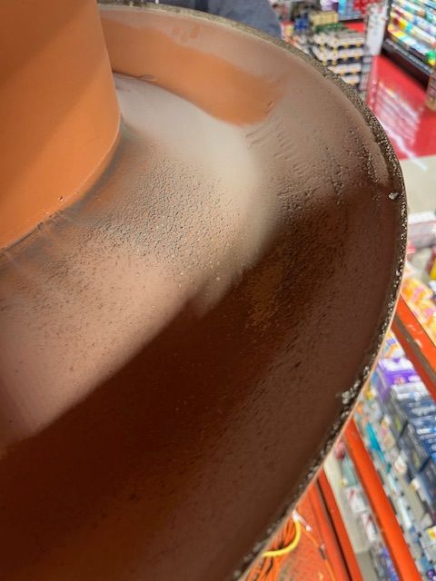 Gros plan sur le rebord intérieur d'un pot en terre cuite, montrant des résidus blanchâtres, probablement des traces d'eau.