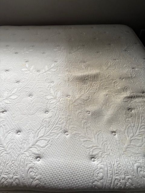 Matelas blanc taché, présentant des creux.