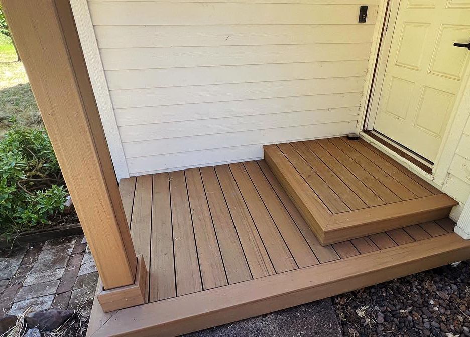 Composite deck porch with a step up to a front door.