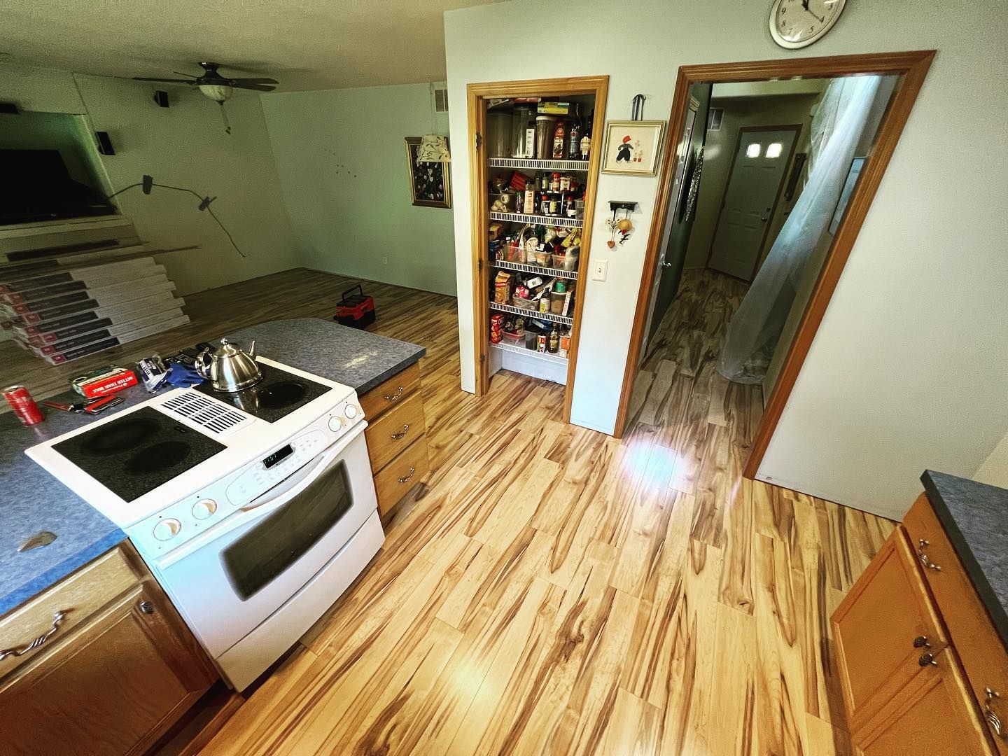Kitchen with a stove, pantry, and wooden floors. Doorways lead to other rooms.