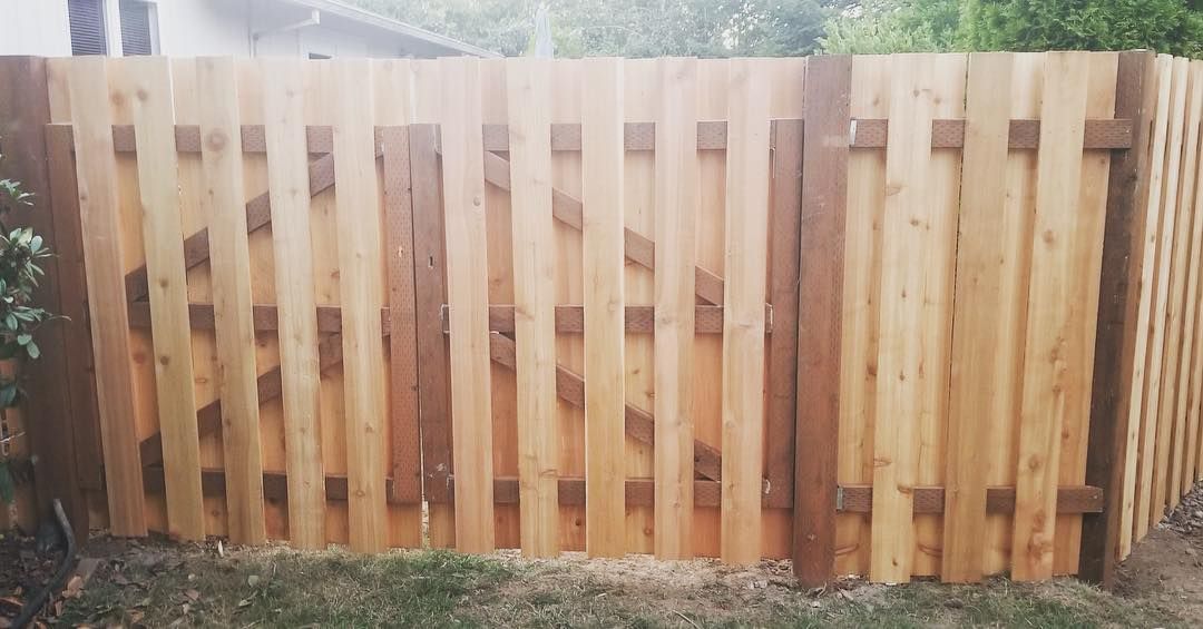 Wooden fence with gate, light brown planks, darker brown posts.