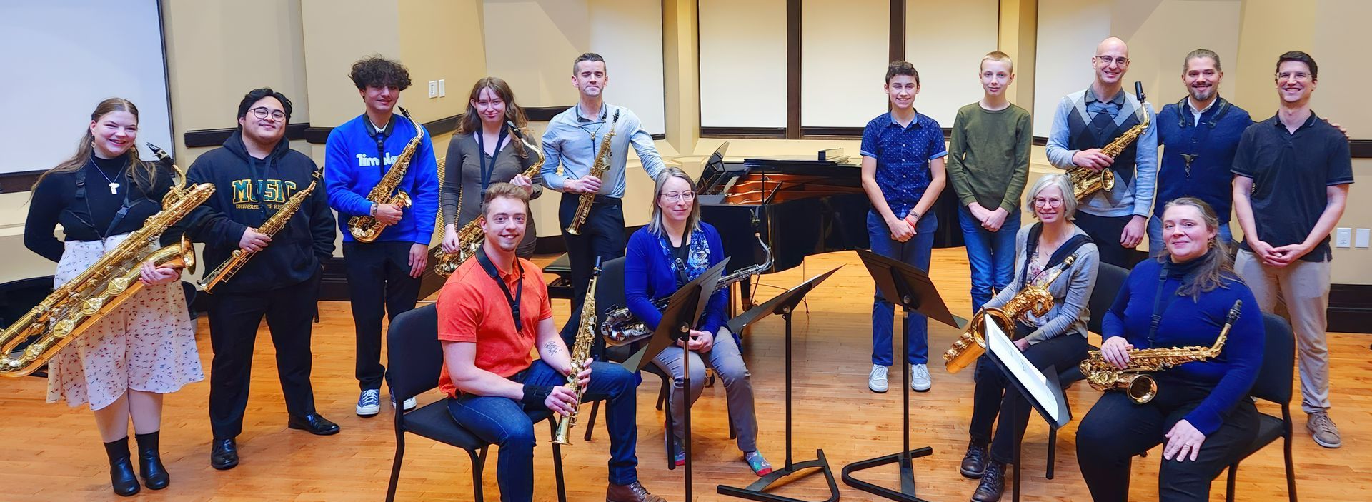 A group of people standing next to each other musical instruments in a room.
