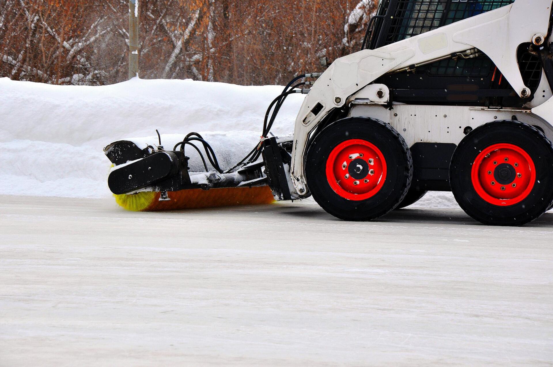 white bulldozer scraping the snow