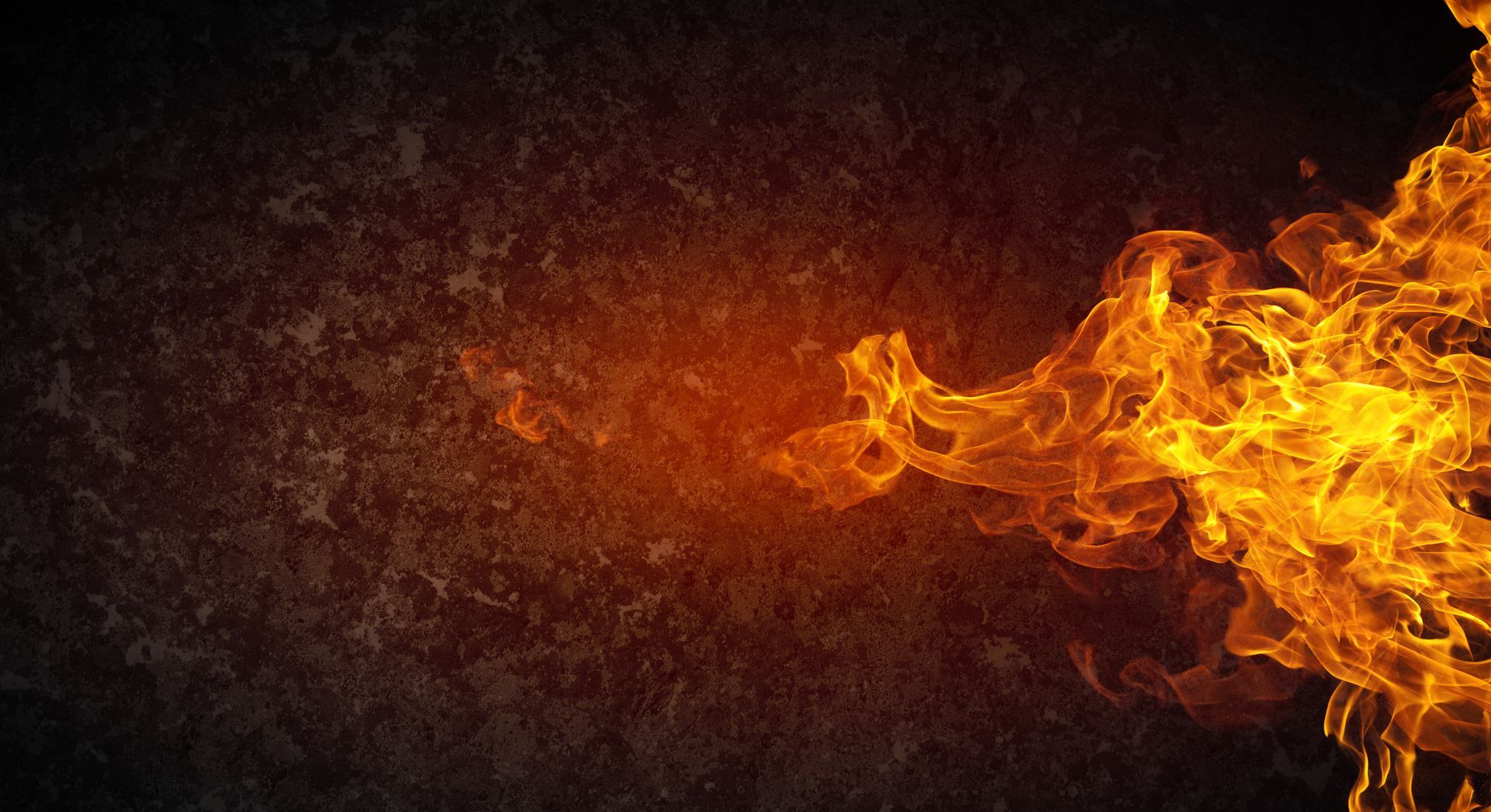 Flames of fire against a textured, dark background, emanating from the right side.