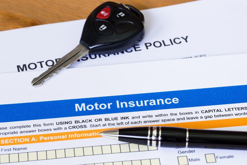 A Car Key Sits on Top of a Motor Insurance Policy — FNQ Windscreens in Bungalow, QLD