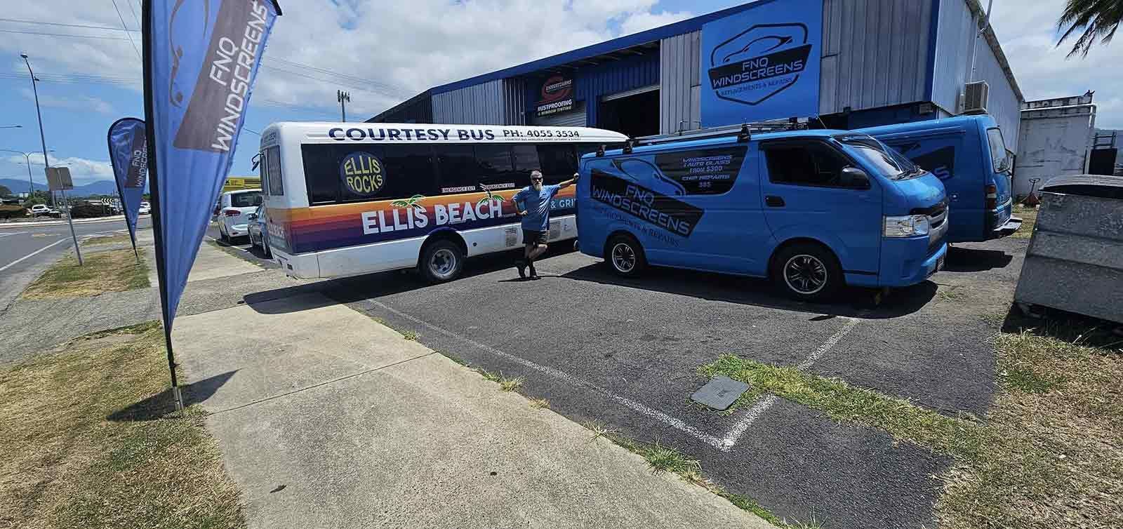 A Group of Blue Vans Parked in Front of a Building — FNQ Windscreens in Bungalow, QLD