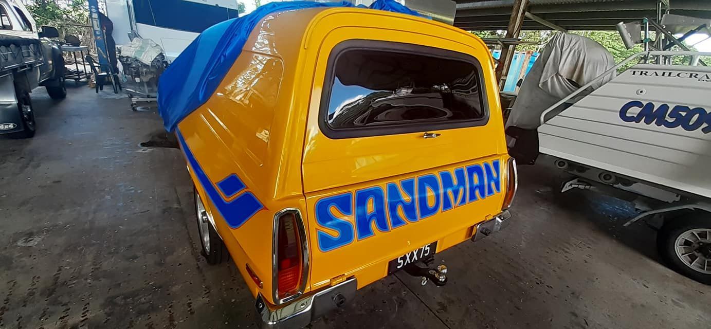 A Yellow Van With Blue Writing on the Back is Parked in a Garage — FNQ Windscreens in Redlynch, QLD