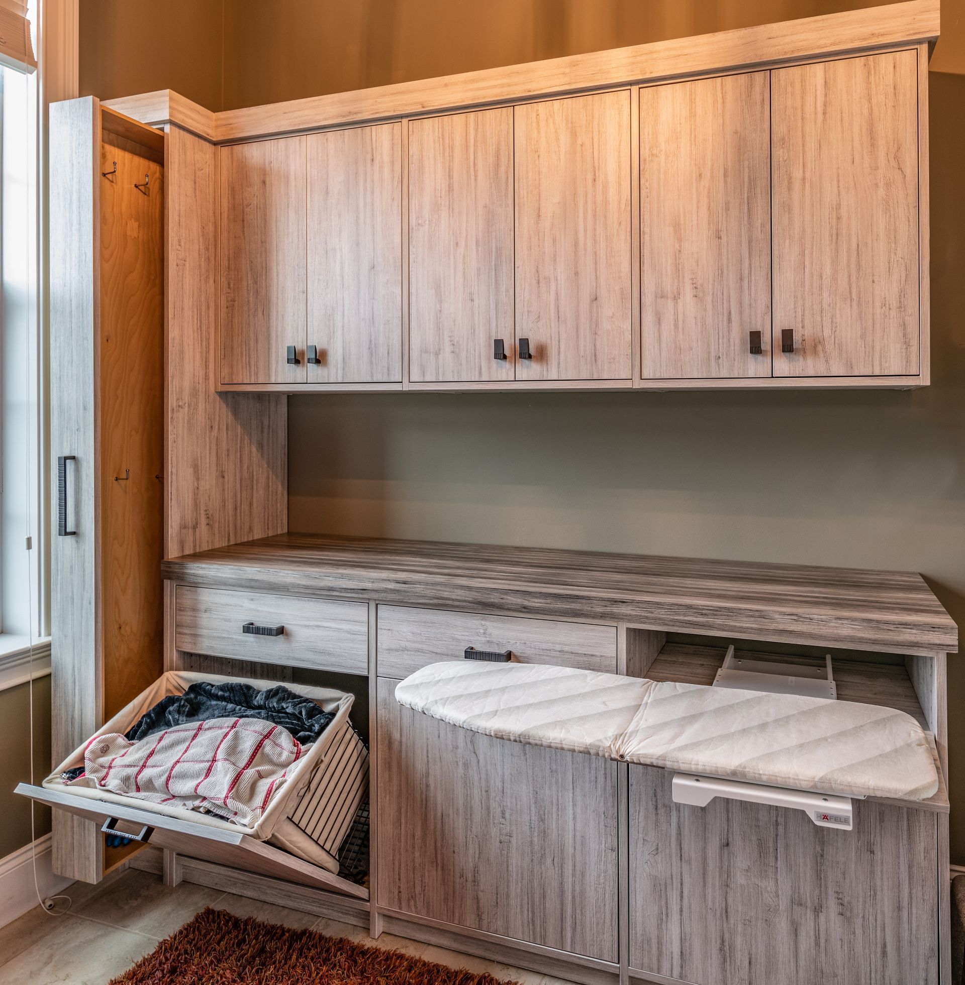 Woodgrain built-in cabinetry with open pull-out storage and a fold-down table in a small room
