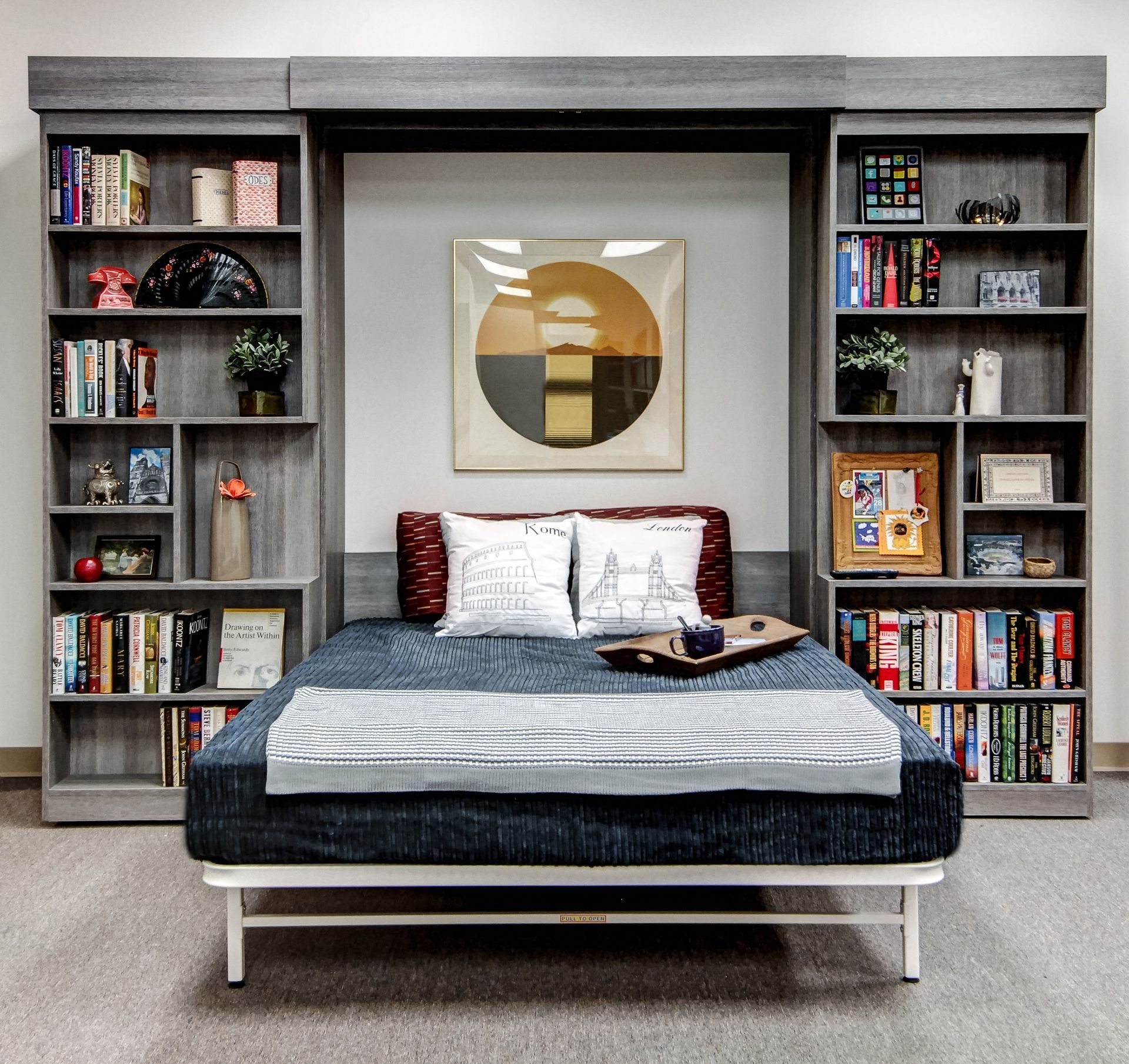 Modern bedroom with a bed centered between built-in bookshelves and a geometric wall art piece