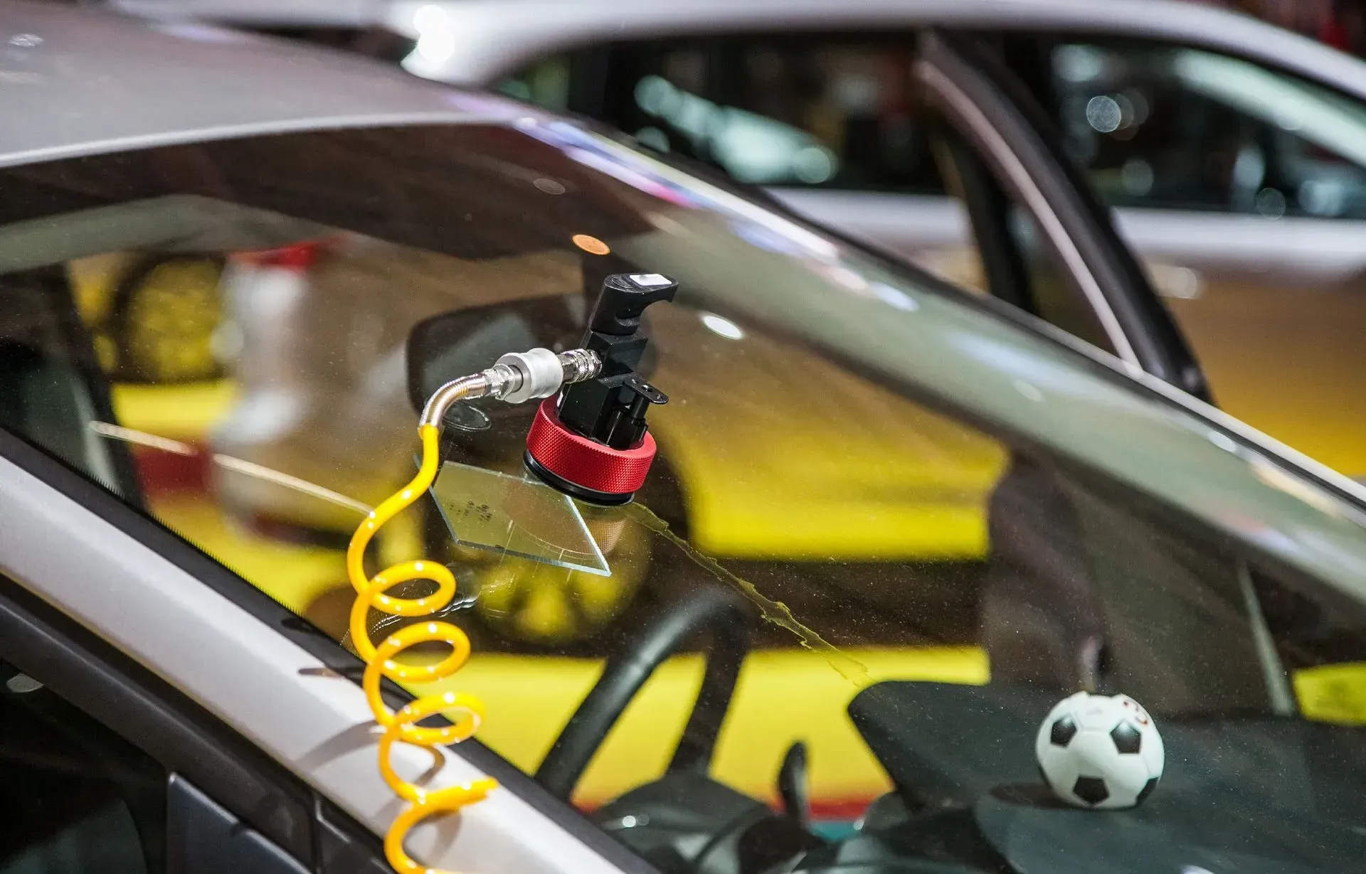 Chip Repair in Arizona Auto Glass Shop A car windshield is being repaired with a soccer ball on the dashboard.