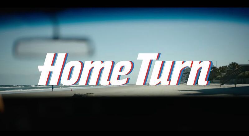 “Home Turn” title over a blurred road-view background in white and pink text