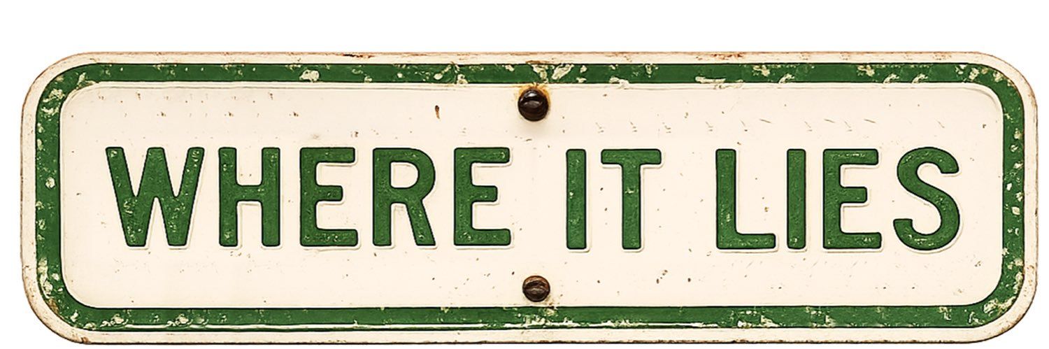 Vintage white sign with green border reading “WHERE IT LIES”