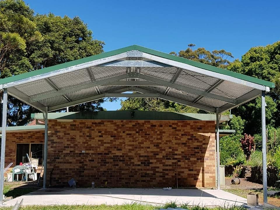 Carport With a Green Roof Attached to a Brick Building. the Roof is Metal and Supported by Metal Poles — North Coast Sheds & Garages in Coraki, NSW