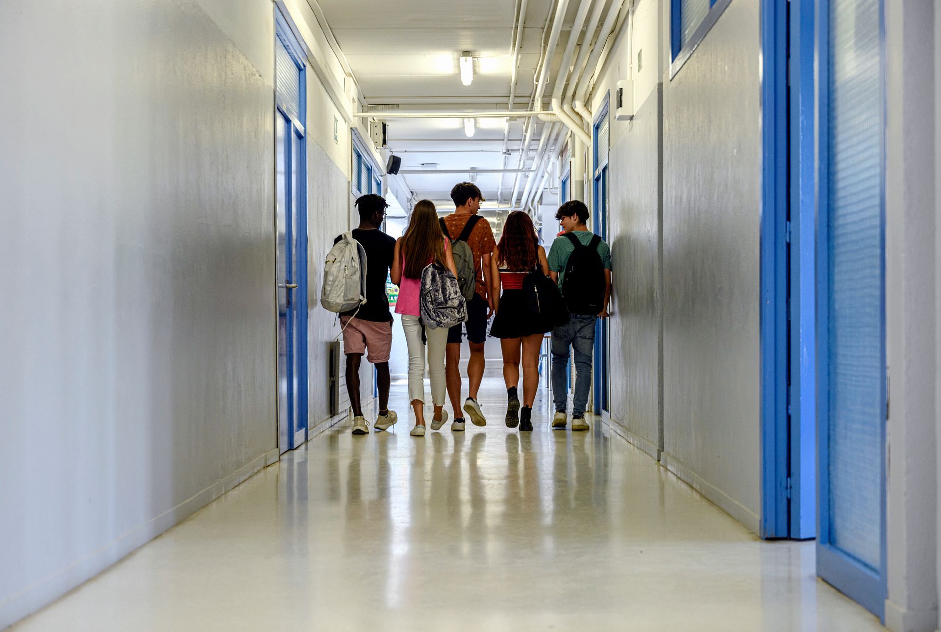 Un gruppo di studenti sta camminando lungo un corridoio.