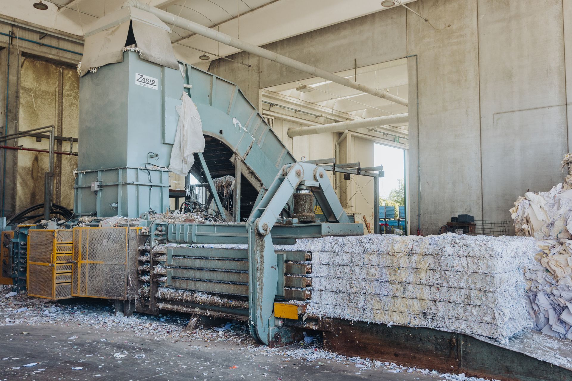 Macchina industriale per la compattazione di balle di materiale triturato all'interno di un impianto di riciclaggio del calcestruzzo.