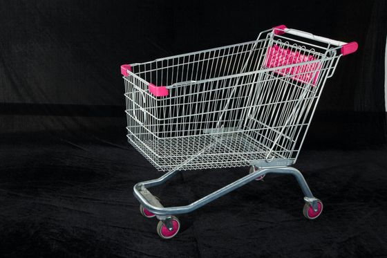 Carrello della spesa in filo metallico rosa e grigio su sfondo nero