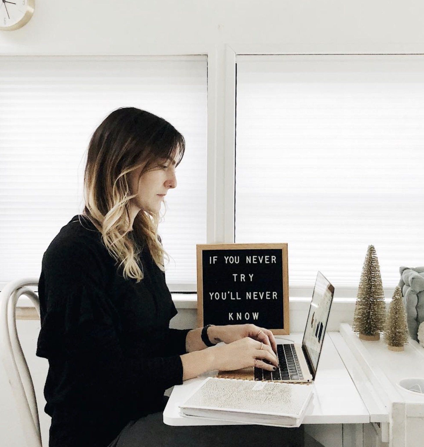 Debbie Mayes sits at her laptop while working on her Pinterest Marketing Strategy.