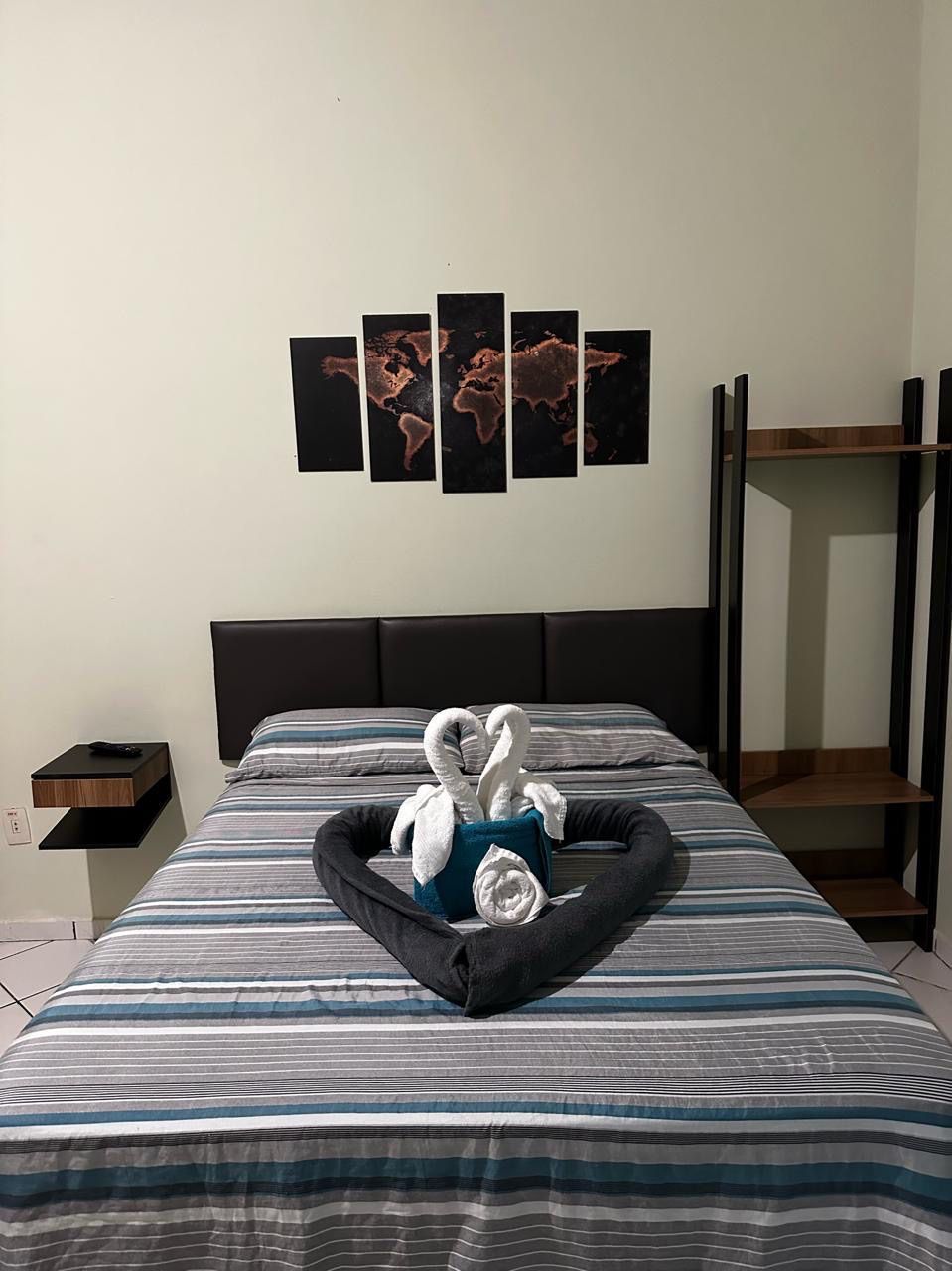 Um quarto com uma cama e um mapa na parede. Pousada Meraki