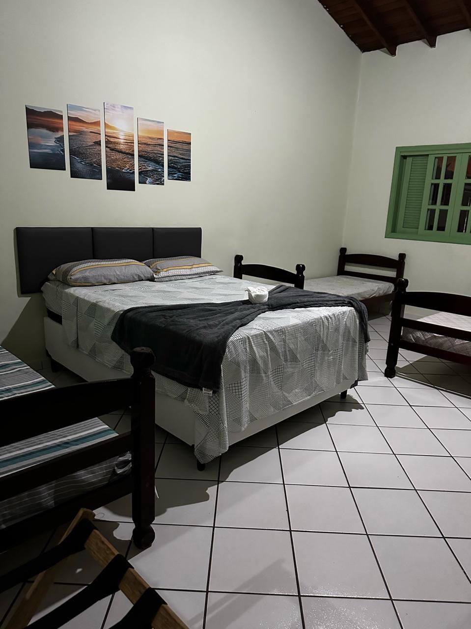 Um quarto com uma cama, duas cadeiras e uma janela. Pousada Meraki