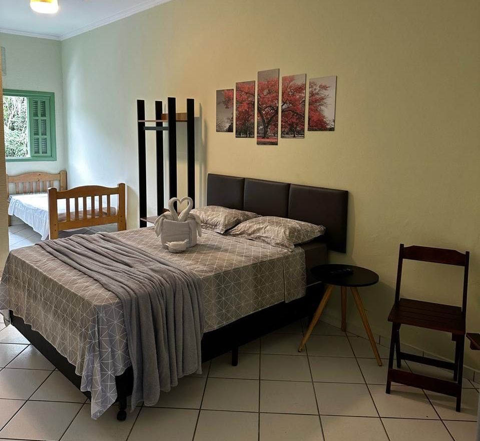Um quarto com uma cama grande e uma cadeira Pousada Meraki