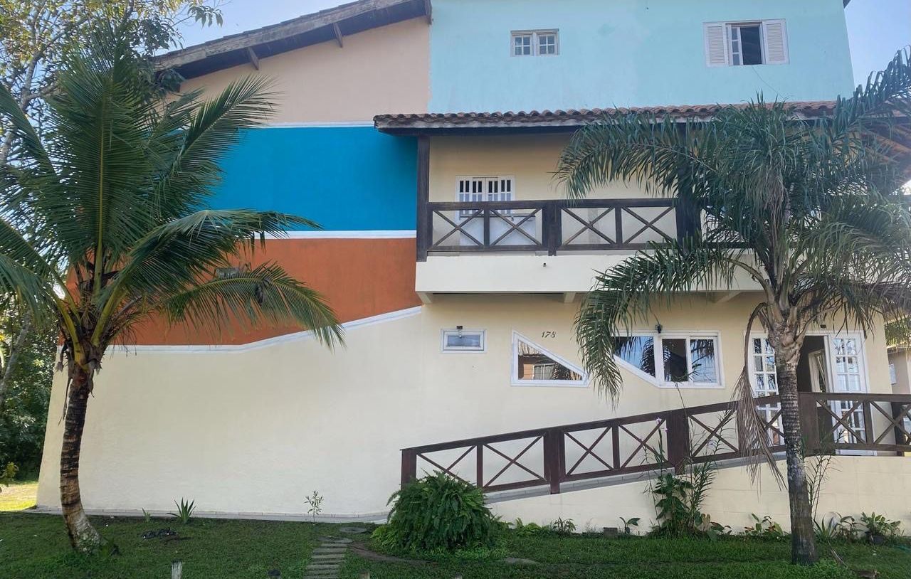 Uma casa grande com uma rampa que leva até ela e uma palmeira na frente dela. Pousada Meraki