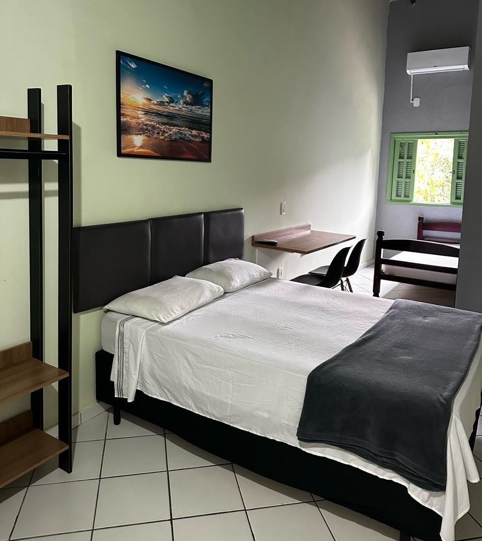 Há uma foto na parede acima da cama no quarto. Pousada Meraki