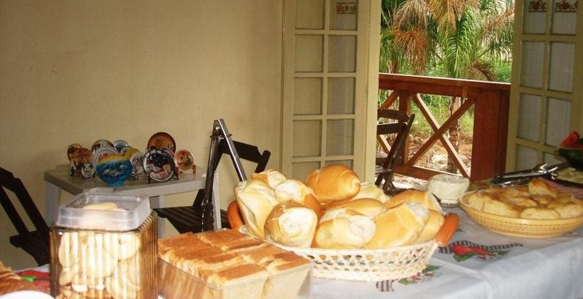 Uma mesa com uma cesta de pães sobre ela Pousada Meraki