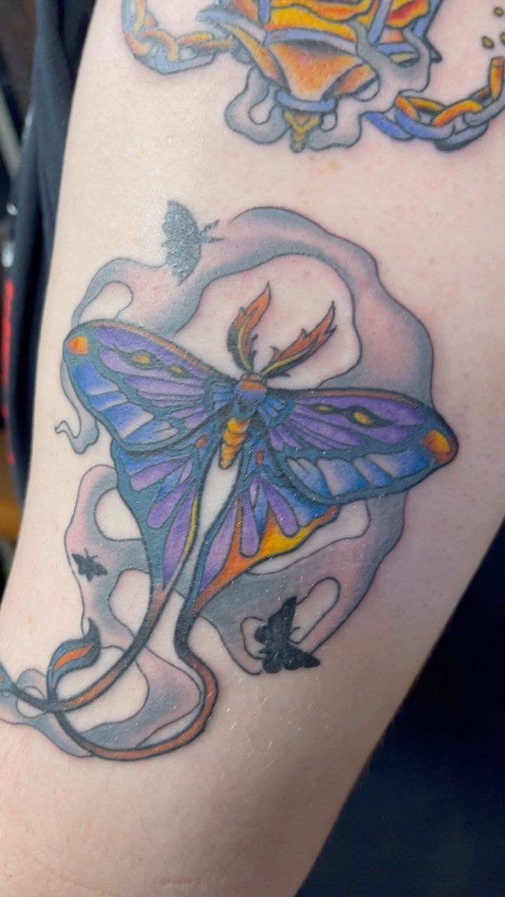 A person has a tattoo of a butterfly on their arm