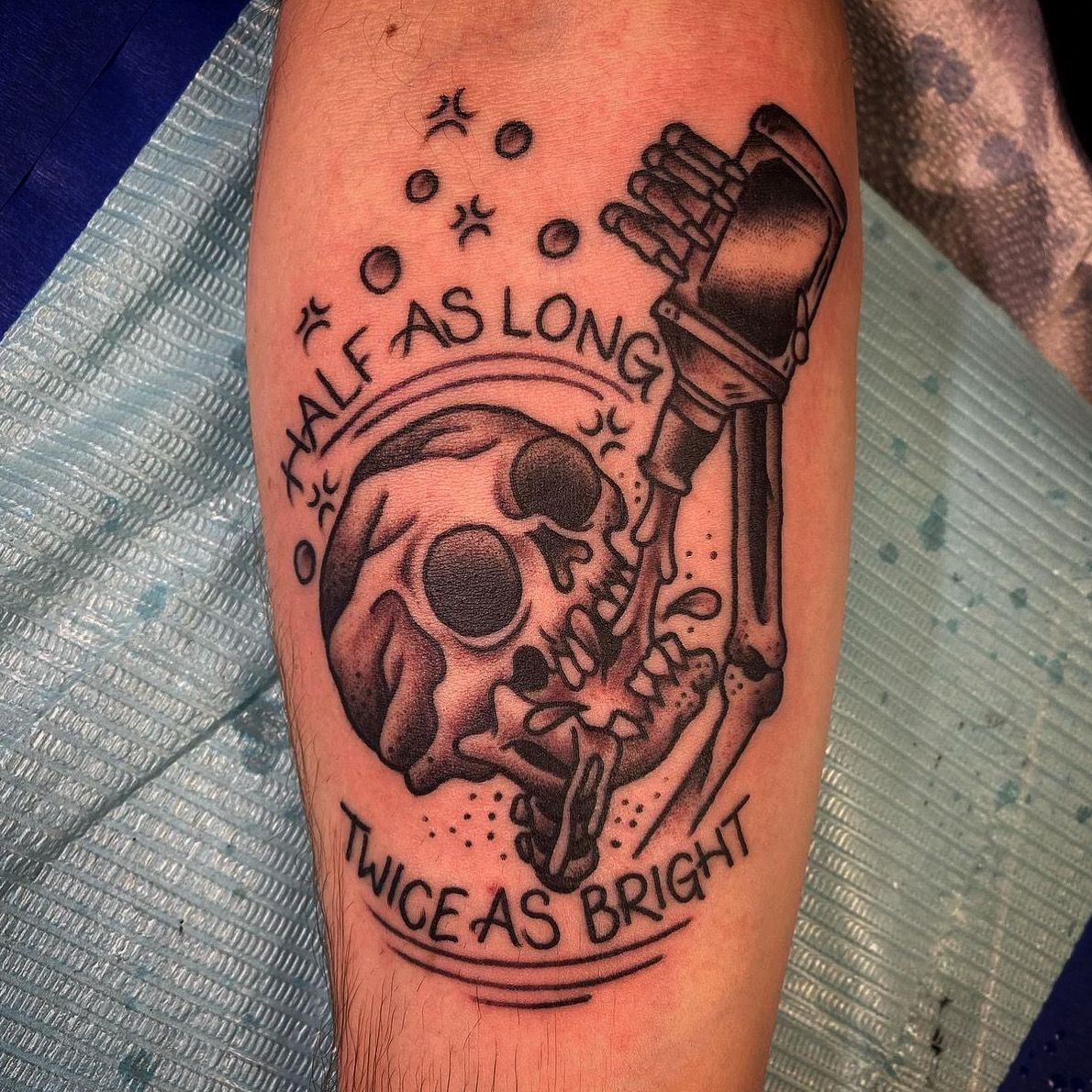 Tattoo of a skull being drilled by a jackhammer. Text: 