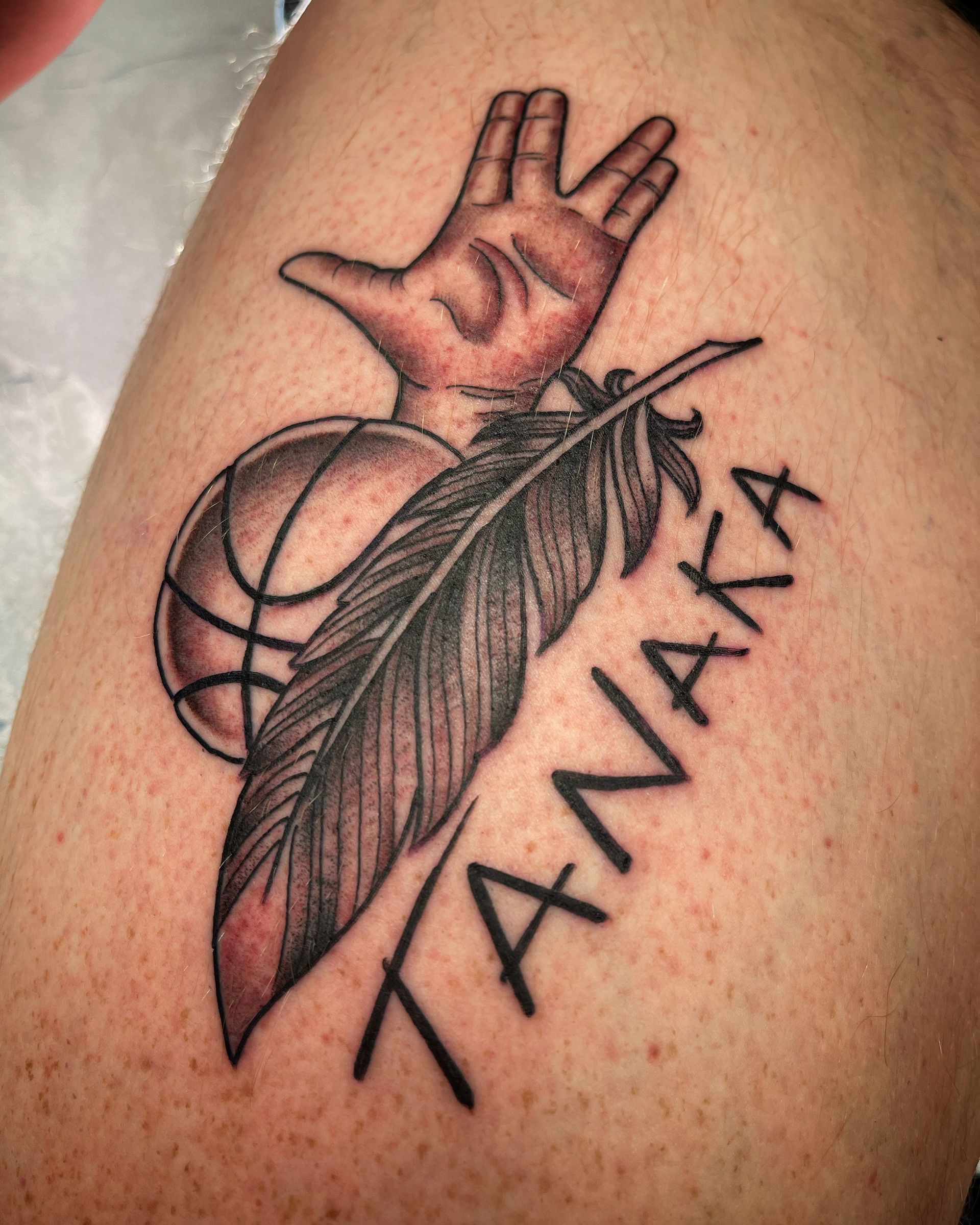 Tattoo on skin: hand gesture, basketball, feather, and name 