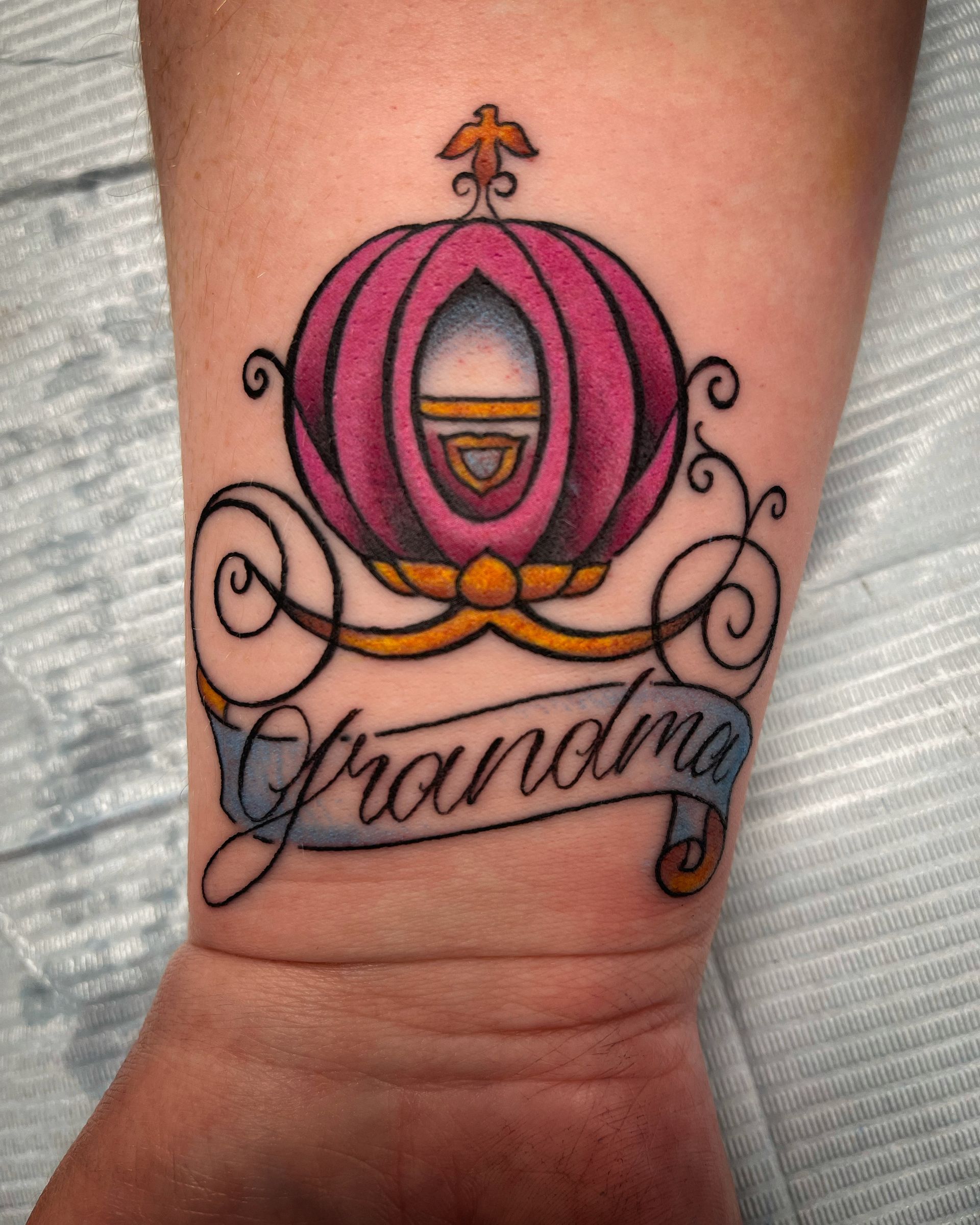Tattoo of a pink Cinderella carriage with 