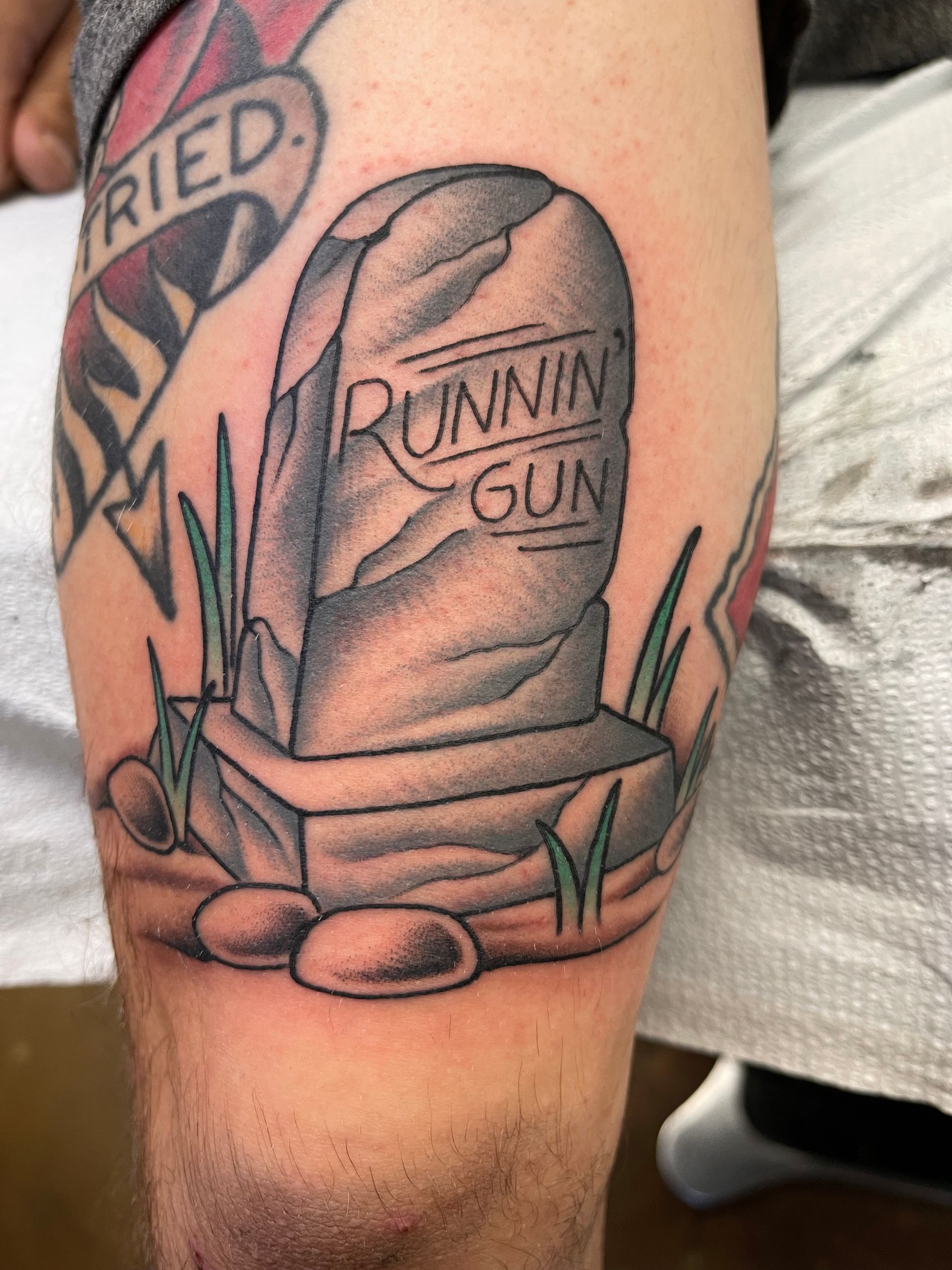 Tattoo of a tombstone that reads 