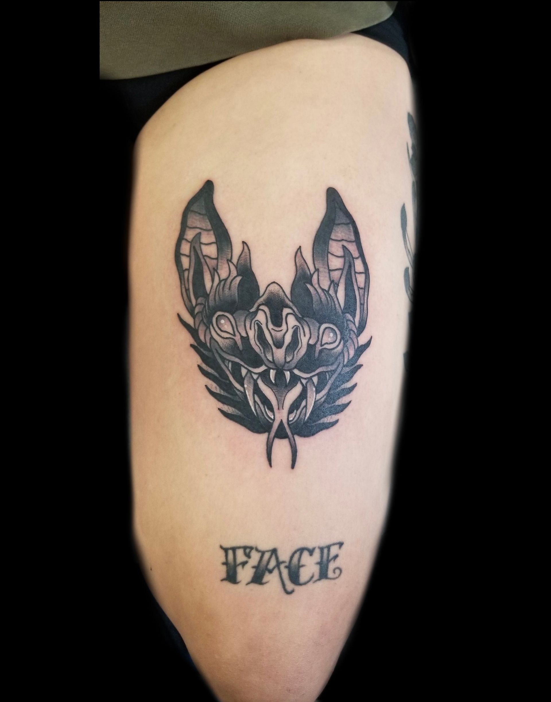 Black ink bat tattoo on skin with 