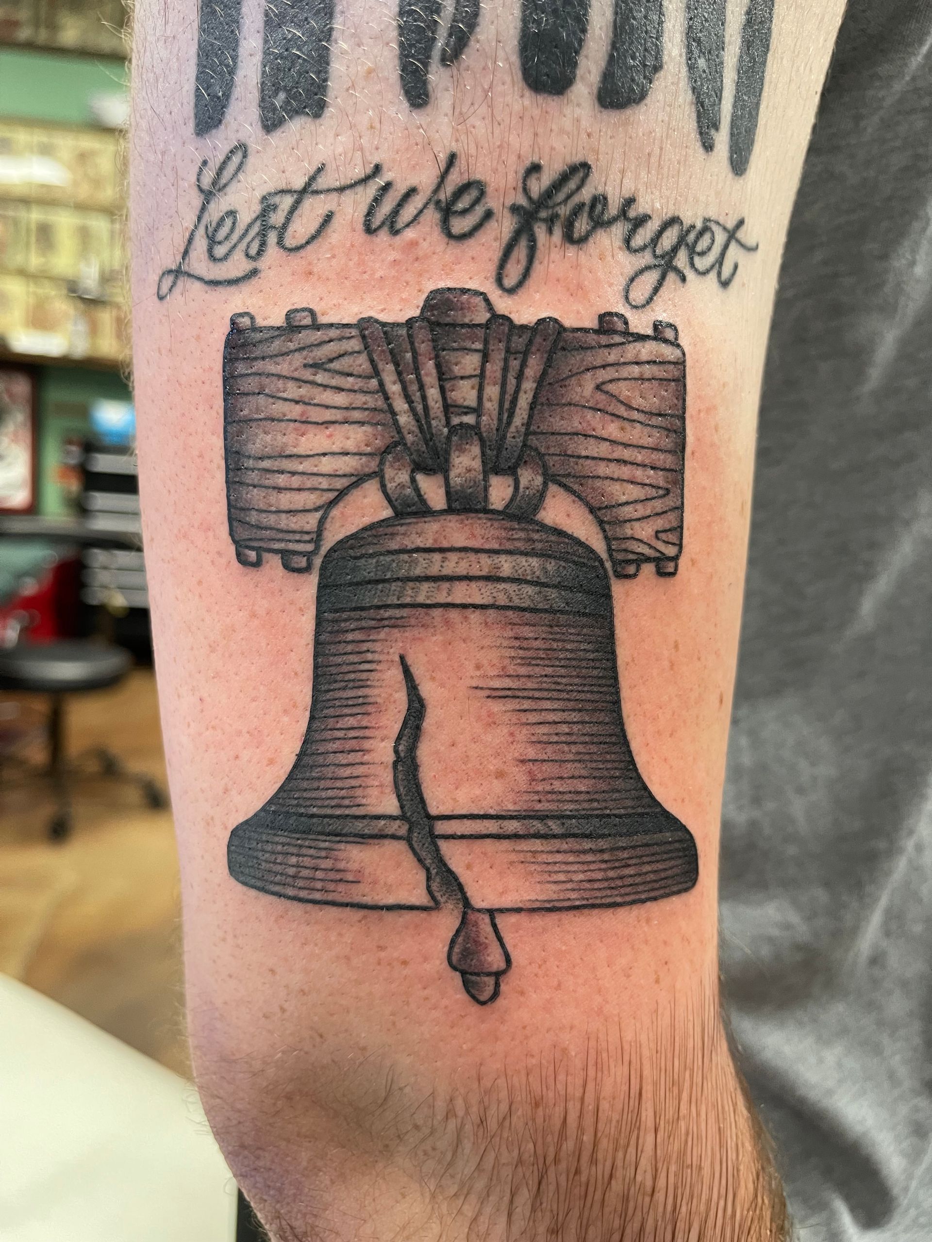 Tattoo of the Liberty Bell with the words 