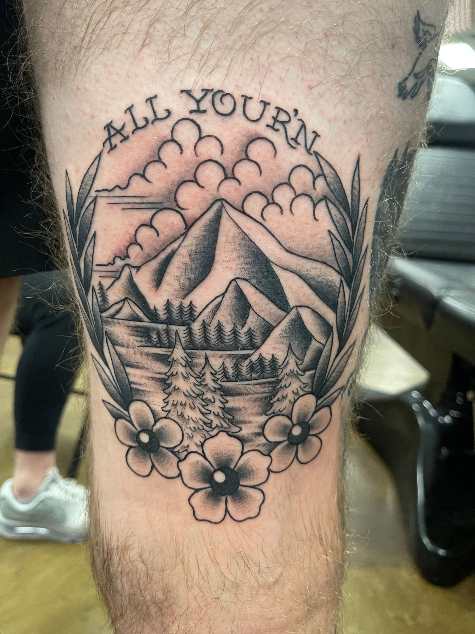 Tattoo of a mountain landscape with text 