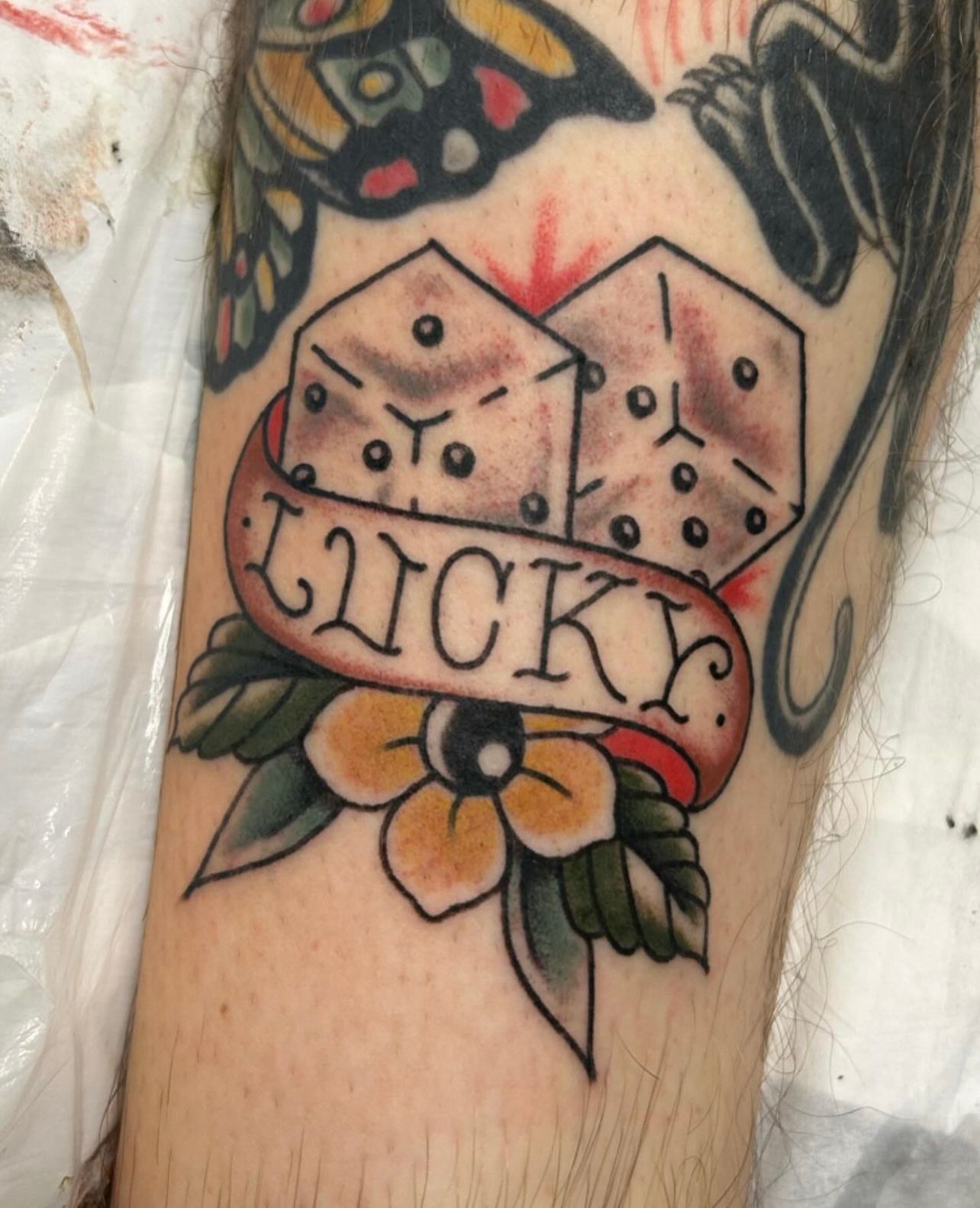 Tattoo of dice with banner reading 