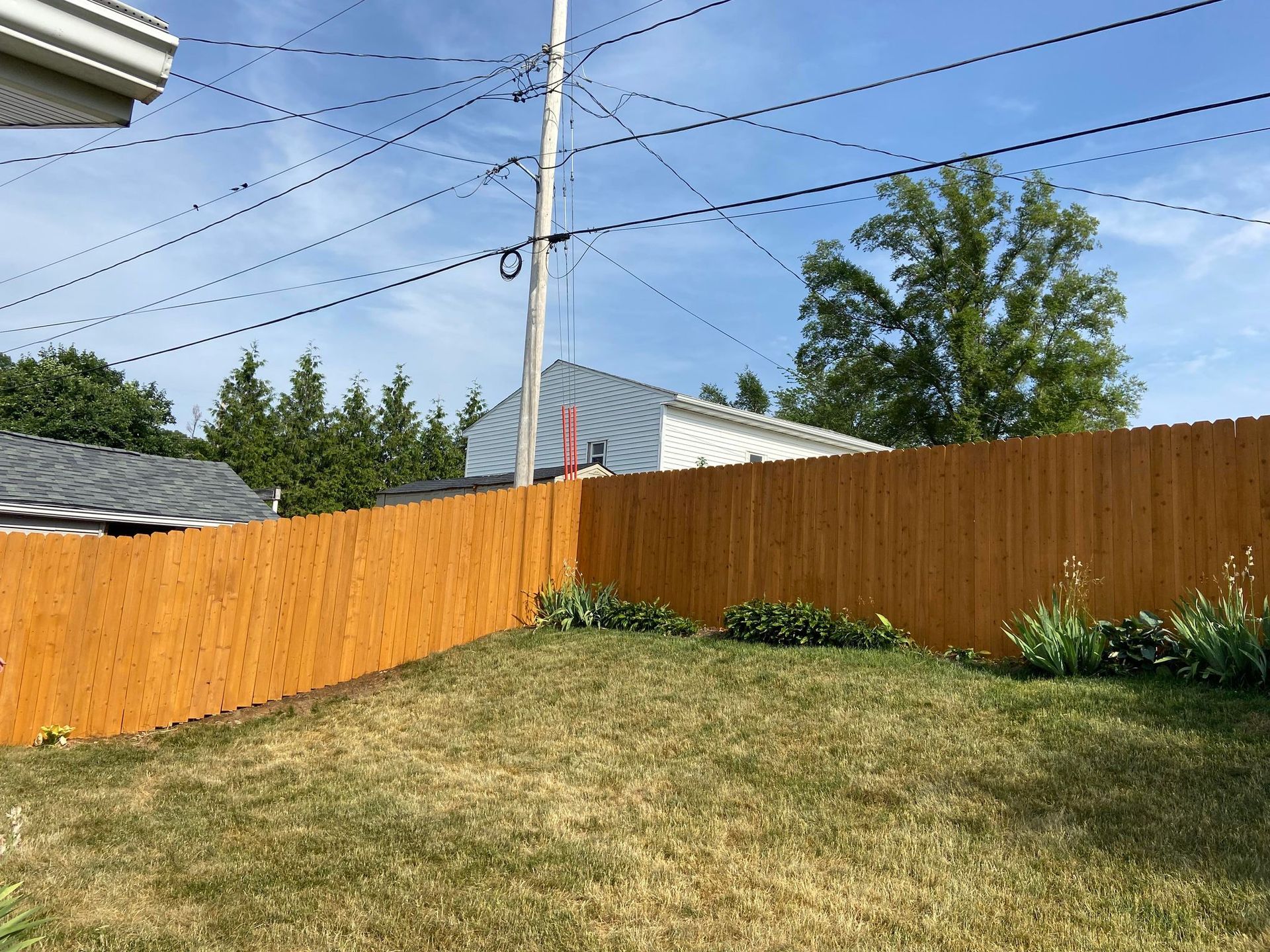 There is a wooden fence in the backyard of a house.
