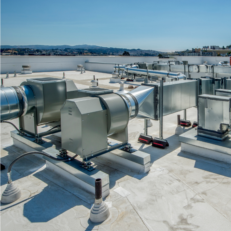 A rooftop with a lot of pipes and fans on it