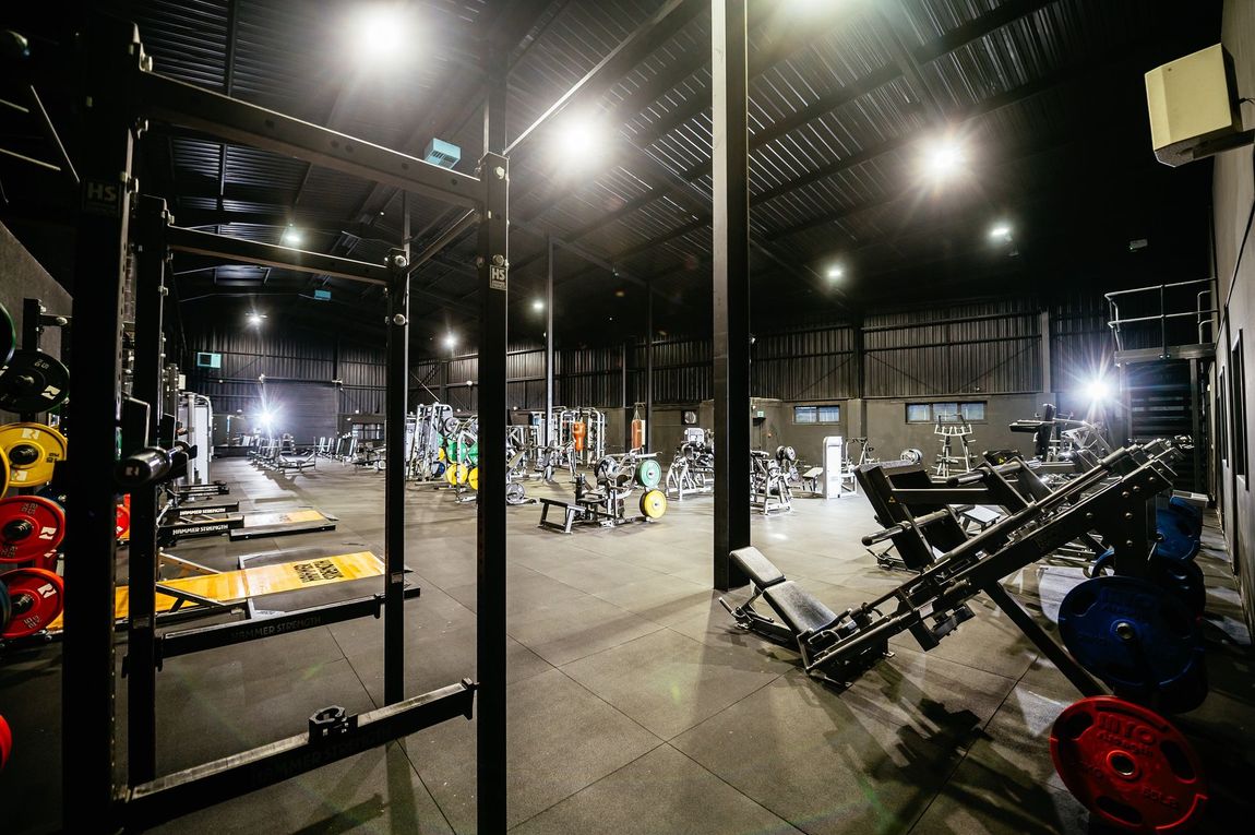 The super-sized Hammer Strength main gym inside Caerphilly’s biggest gym, featuring premium strength-training machines and free weights at Team Rees Gym.
