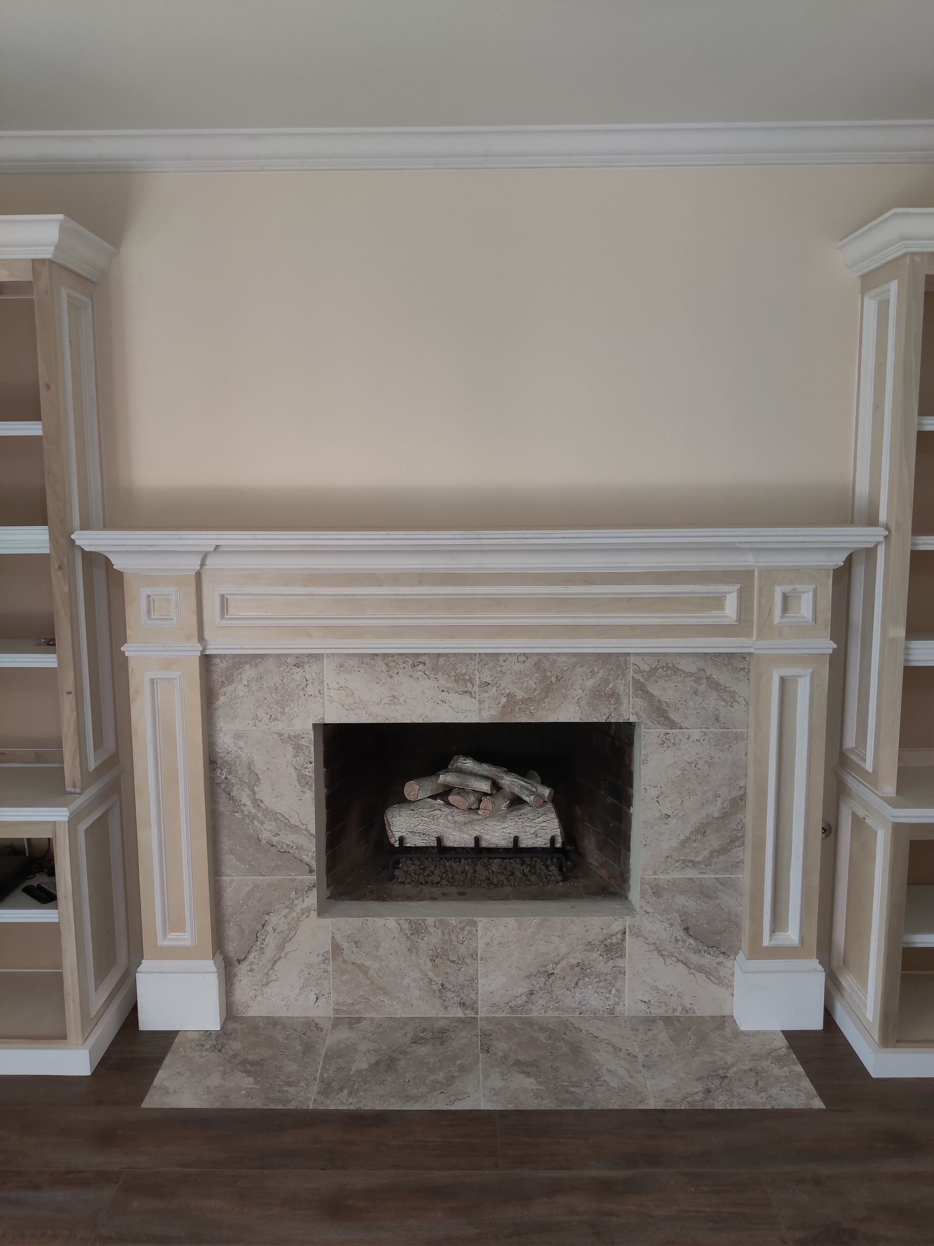 Elegant beige fireplace with white mantel and marble surround in a living room